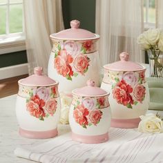 pink and white ceramic kitchen canisters with roses on them