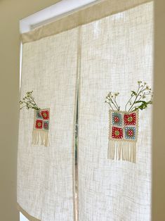 two embroidered curtains with flowers on them