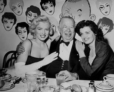 a group of people sitting at a table with plates and cups in front of them