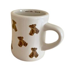 a white coffee mug with brown teddy bears painted on it's front and sides