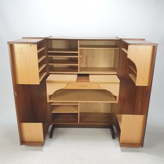 an open wooden cabinet with shelves and drawers