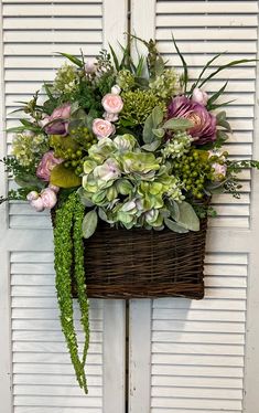 a basket filled with lots of flowers sitting on top of a door