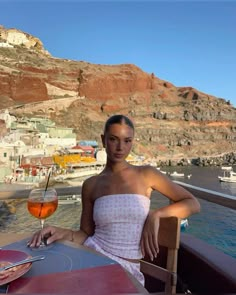 a woman sitting at a table with a glass of wine in front of her on the boat