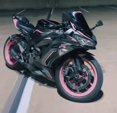 a pink and black motorcycle parked in a parking lot