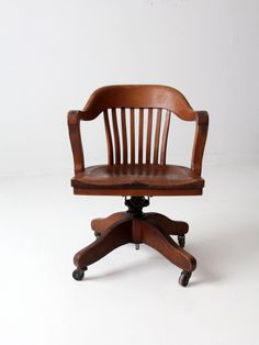 an office chair sitting on top of a wooden desk next to a white wall and floor