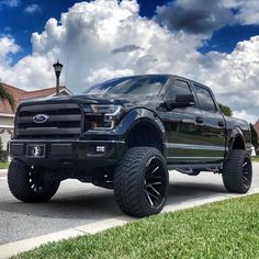 a black truck is parked on the street