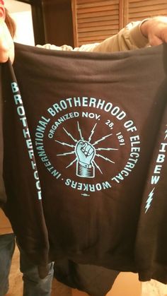 someone holding up a t - shirt with the words brotherhood on it