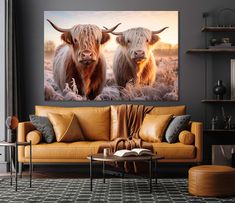 two cows standing next to each other on a wall above a couch in a living room