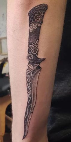 a tattoo on the leg of a man with a knife in it's center