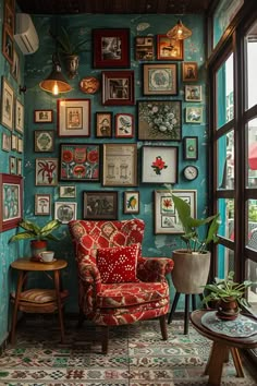 a room filled with lots of framed pictures on the wall next to a red chair