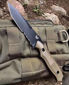 a large knife laying on top of a bag