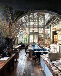 the dining room is set up with tables, chairs and vases in front of an arched glass window