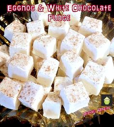 white chocolate fudge on a glass platter with gold foil around it and the words eggnog and white chocolate fudge