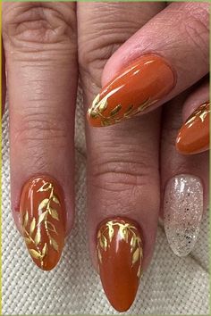 Get ready to fall in love with this vibrant and bewitching Orange Fall Manicure featuring elegant gold floral accents. Embrace the beauty of autumn with this chic nail design, boasting warm earth tones that radiate seasonal charm. Delicately painted golden leaf motifs add a touch of elegance, making these stunning nails the perfect accessory to complement your Thanksgiving ensemble. // Photo Credit: Instagram @drigotbars Copper Nails Designs, Turkey Nails, Thanksgiving Nail Designs, Thanksgiving Nail Art, Thanksgiving Nail, Stunning Nails, November Nails, Fall Manicure, Nail Art For Beginners