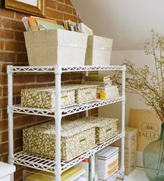 shelving unit with baskets and boxes on it in the corner of a room next to a brick wall