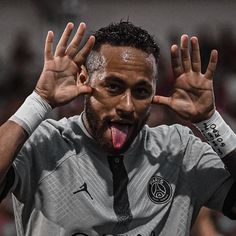 a soccer player with his tongue out and hands in the air, making an obscene gesture