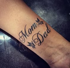 a tattoo that says mom and dad on the wrist