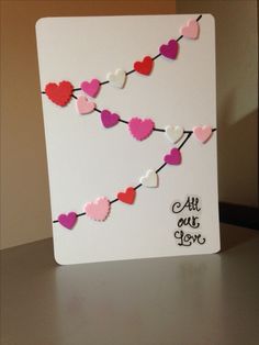 a card with hearts hanging from it on a table