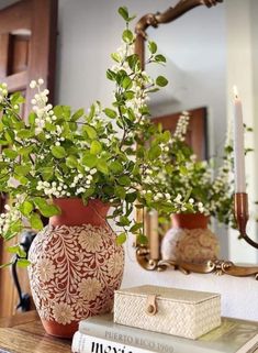 a vase filled with white flowers sitting on top of a table next to a mirror