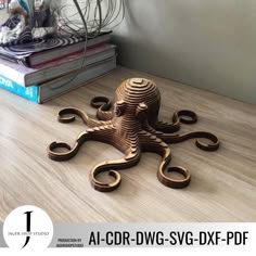 an octopus made out of wood sitting on top of a wooden table next to books