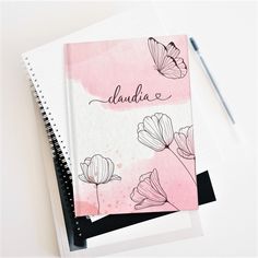 a notebook with the word danda written in cursive writing on it next to a pen