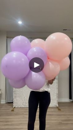 a woman is holding balloons in her hands