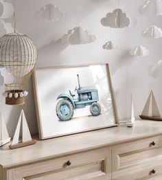 there is a picture frame with a tractor on it next to a dresser and lamp