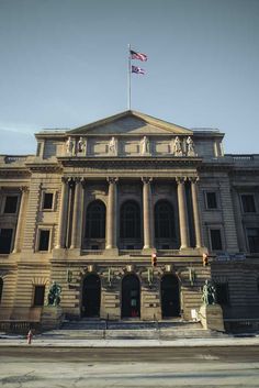 an old building with two flags on top