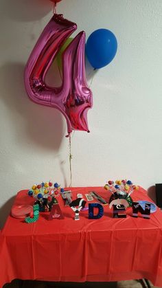 a red table topped with balloons and letters