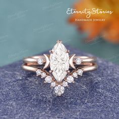 an engagement ring with a pear shaped diamond surrounded by smaller round brilliant cut diamonds in rose gold