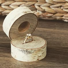 an engagement ring sits on top of a piece of wood