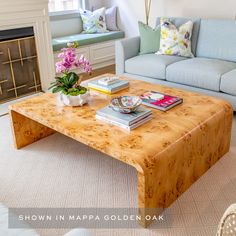 a living room with a couch, coffee table and books on the top of it