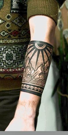 a man's arm with a tattoo on it and a sun in the middle