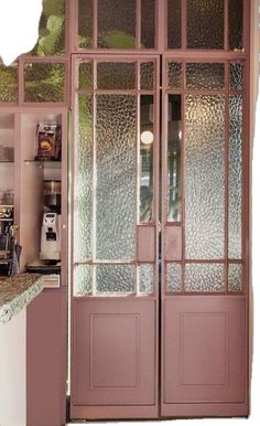 an open glass door in a kitchen next to a counter