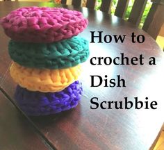 a stack of crochet dish scrubbies sitting on top of a wooden table