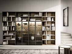 a living room filled with lots of furniture and bookshelves next to a stair case