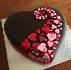 a heart shaped cake with pink and red hearts on it