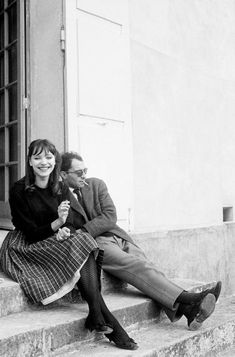 a man and woman sitting on steps next to each other