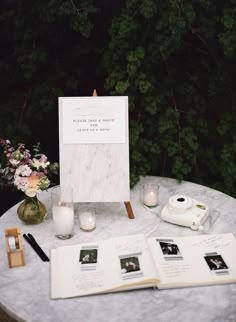 an open book sitting on top of a table next to some candles and other items