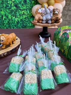 there are many treats on the table with plastic wrappers in front of them and an animal figurine next to it