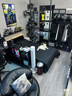 a room filled with lots of black furniture and items on the floor, including a bed