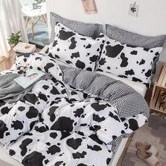 a bed covered in black and white cow print sheets