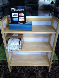 there is a shelf that has some books on it and magazines in front of it