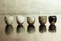 five cups sitting on top of a wooden table