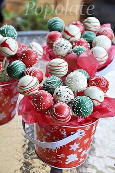 some red and white chocolates are in a bucket on a table with other candies