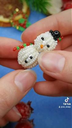 two tiny snowmen are being held in their hands