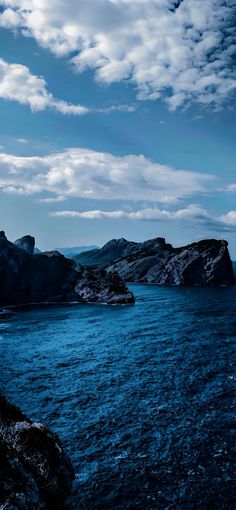 the water is calm and blue with some clouds in the sky