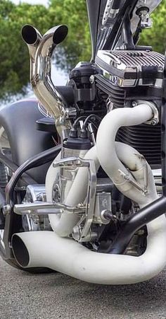 the front end of a motorcycle with exhaust pipes on it's back tire and engine