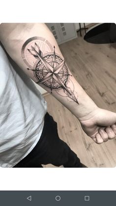 a man with a compass tattoo on his arm