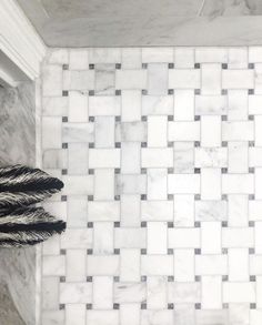 a white tiled bathroom with black and grey accents